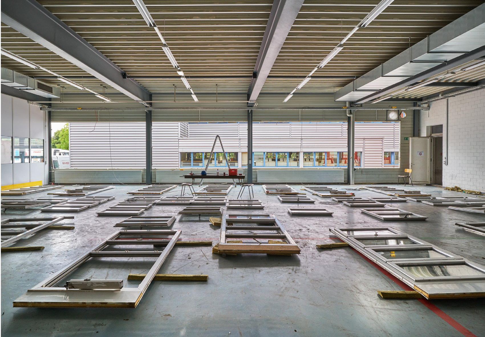 Ausgebaute Fensterelemente ausgelegt zur Vermassung in einer Halle